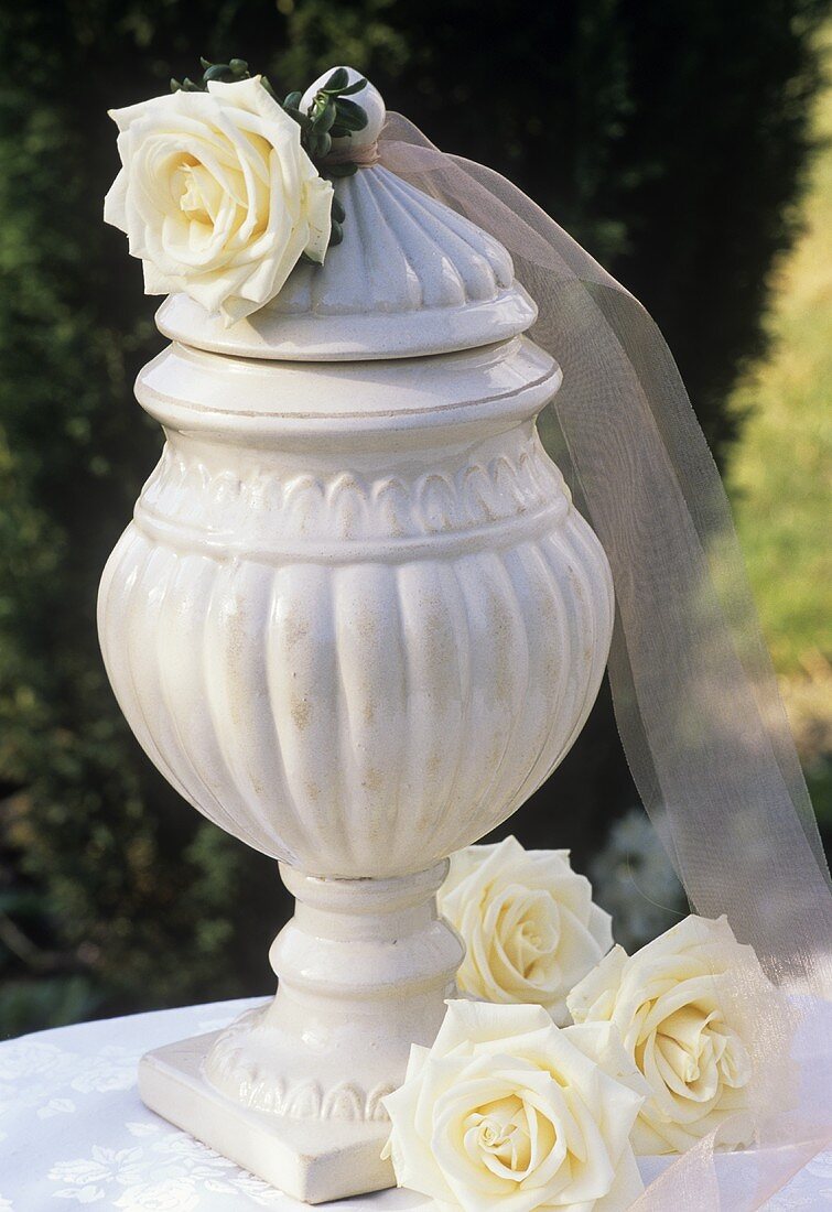Roses ('Maroussia') beside antique-effect vase