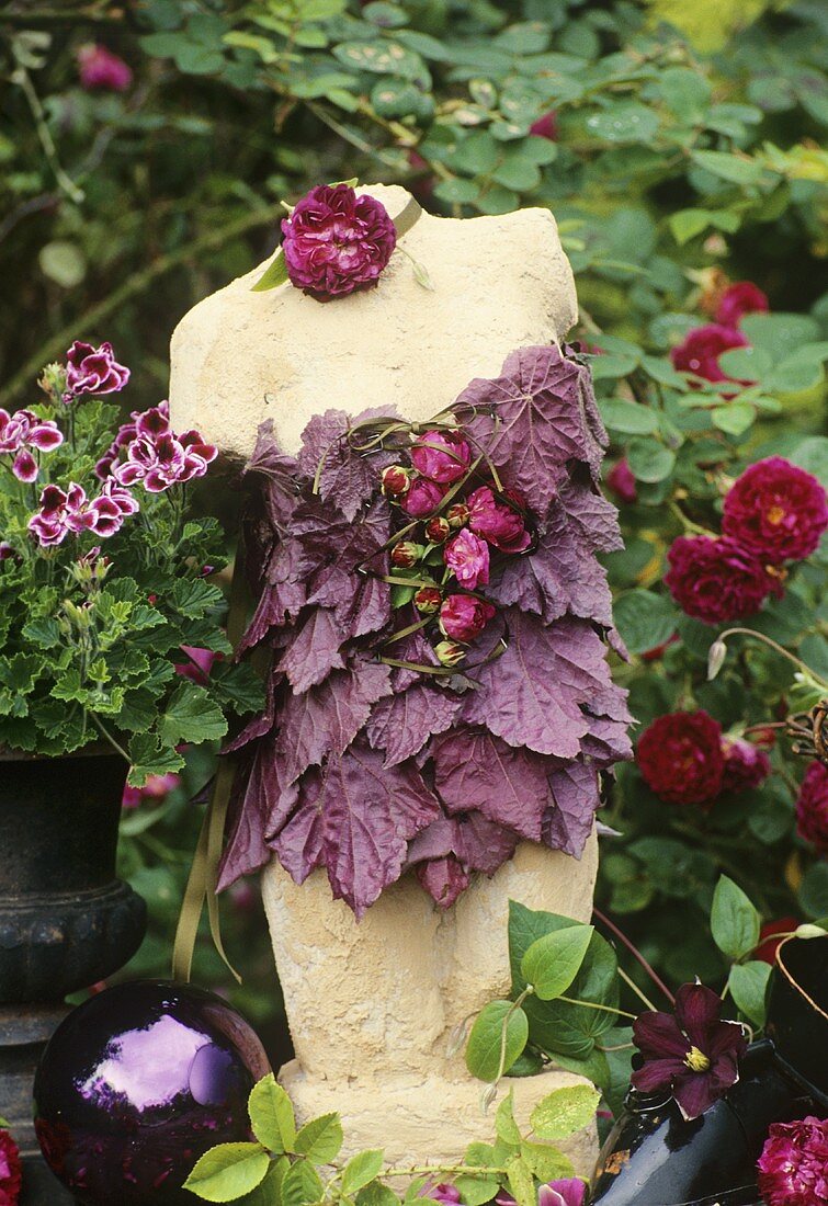 Gartendeko: Torso mit Corsage aus Blättern und Blüten