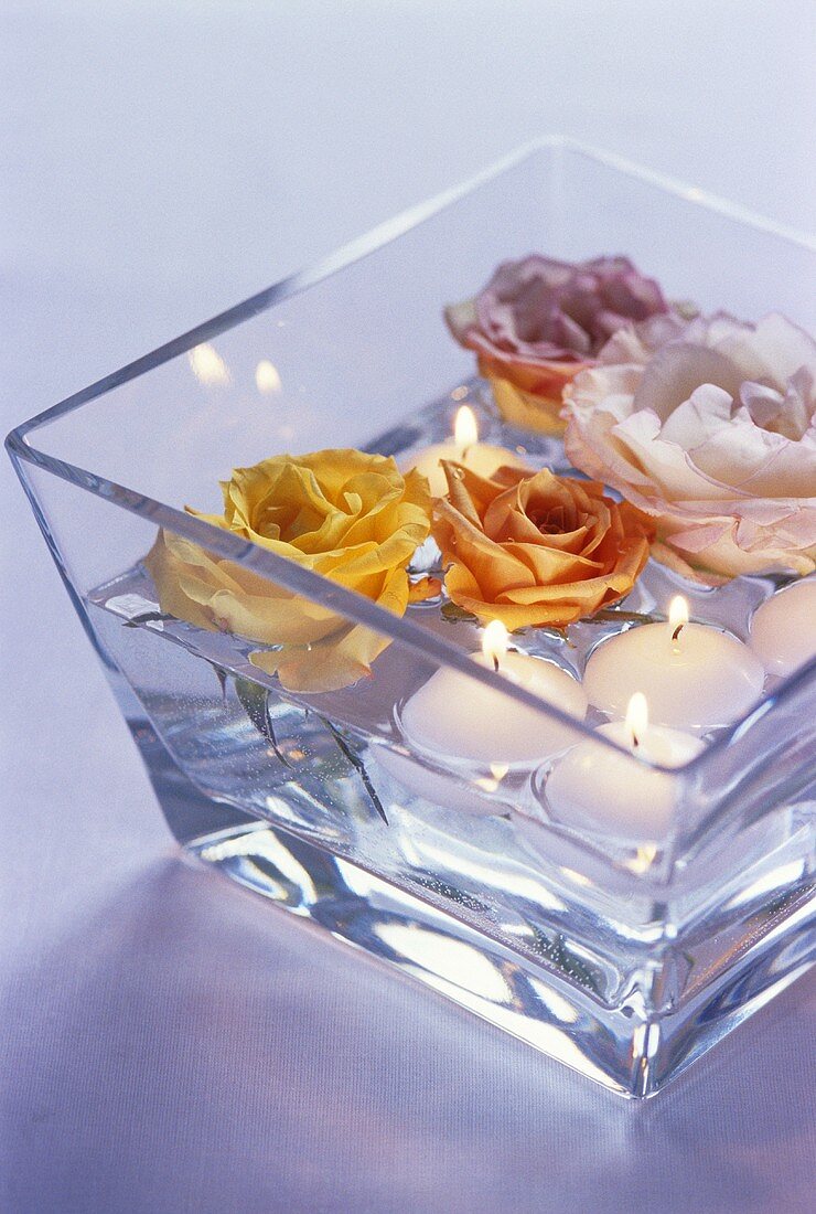 Floating candles and roses in glass bowl