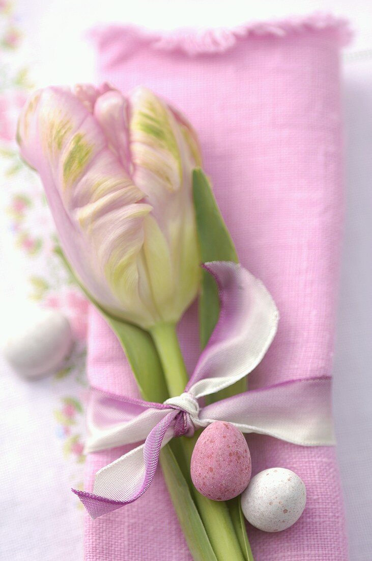 Sweet Easter eggs on a fabric napkin with tulip