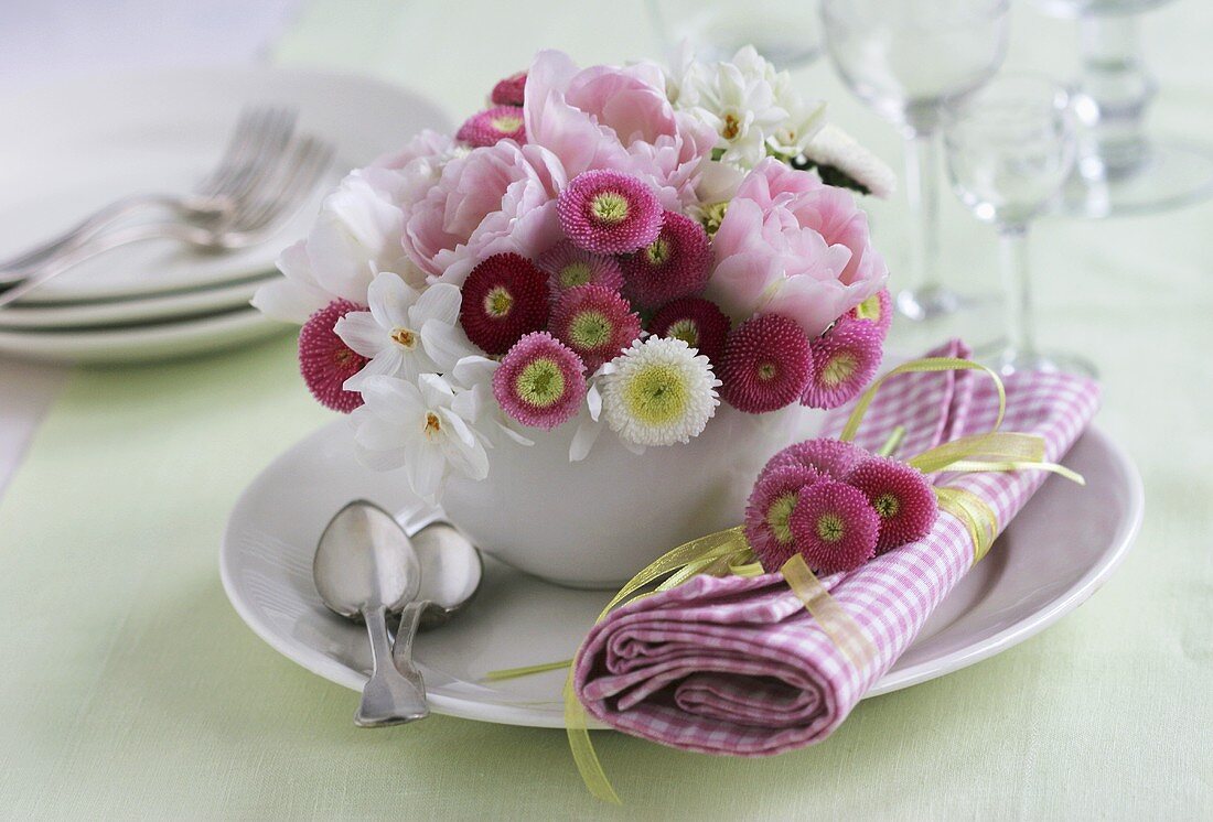 Bellis, tulips and narcissi in a coffee cup