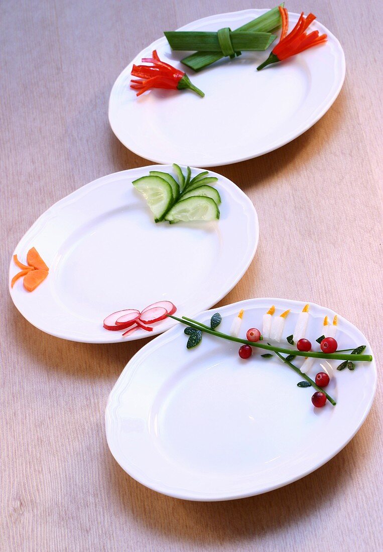 Drei Teller mit verschiedenen Dekorationen aus Gemüse
