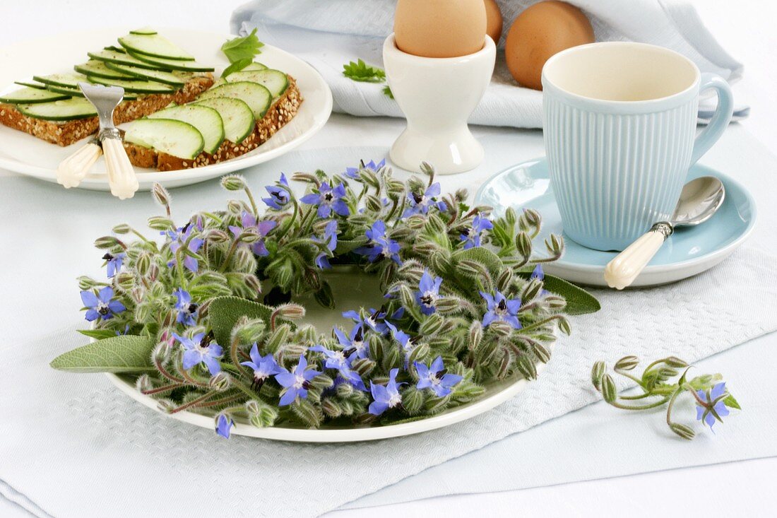 Borretschkranz auf Frühstückstisch mit Ei & Gurkenbrot