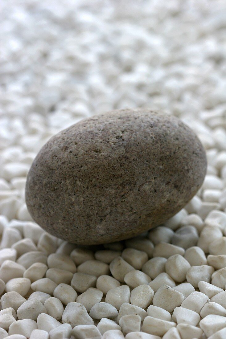 Ein runder Stein auf vielen kleinen Steinen