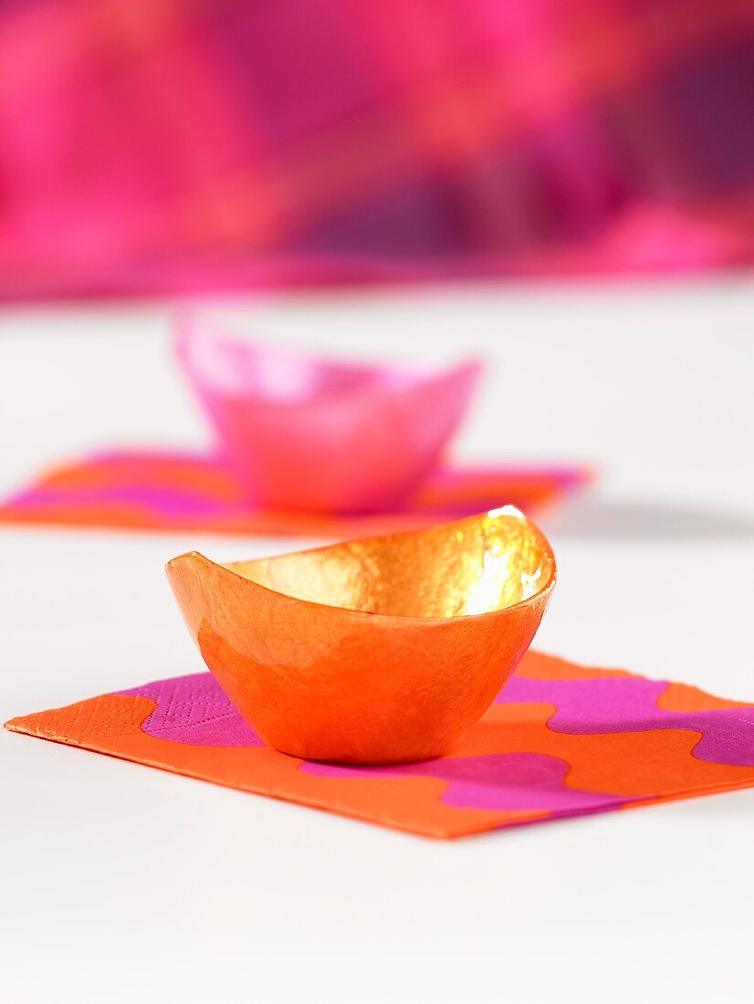 Orangefarbenes und rosa Schälchen als Tischdeko