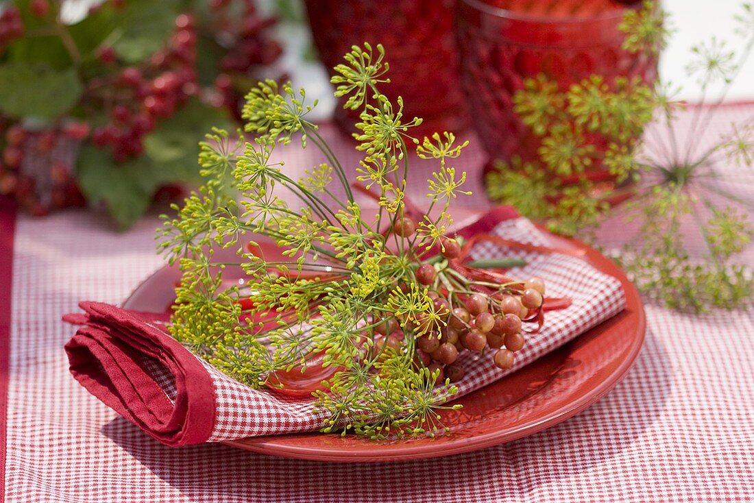 Place-setting with guelder rose berries and dill flowers