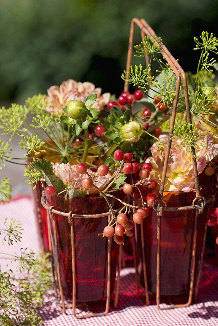 Guelder rose berries, dahlias and dill in glasses