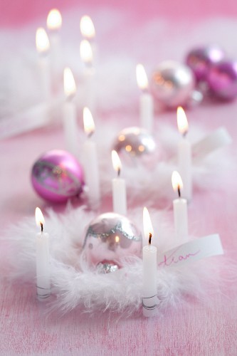 Rosafarbene Weihnachtsdekoration mit Kerzen, Kugeln & Federn