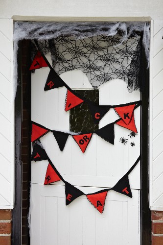 Wimpelkette und Spinnennetz als Halloween Dekoration an Haustür
