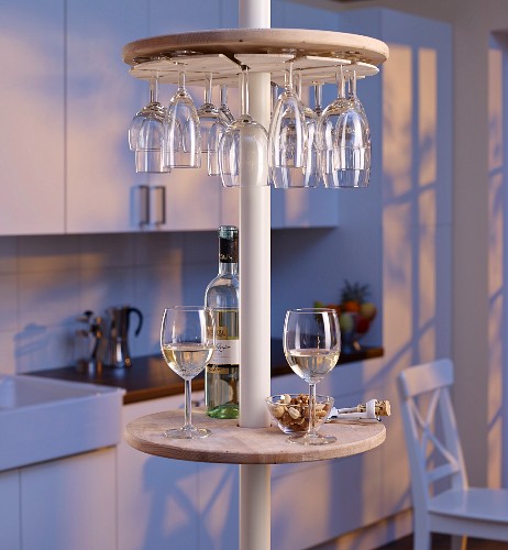 Round minibar with wine glass rack on telescopic pole in kitchen