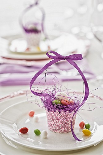 Festive Easter table decoration with hand-crafted paper basket and purple ribbon