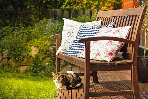 Colourful scatter cushions on garden bench