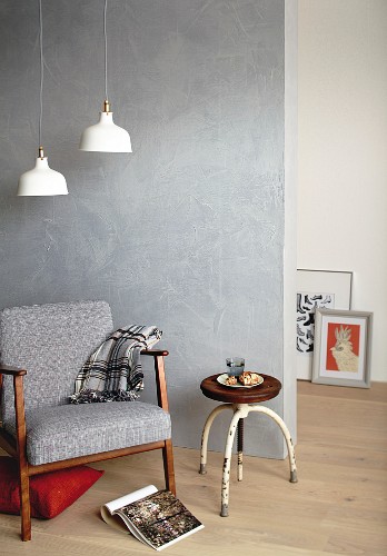 Retro armchair and stool in front of concrete-effect wall