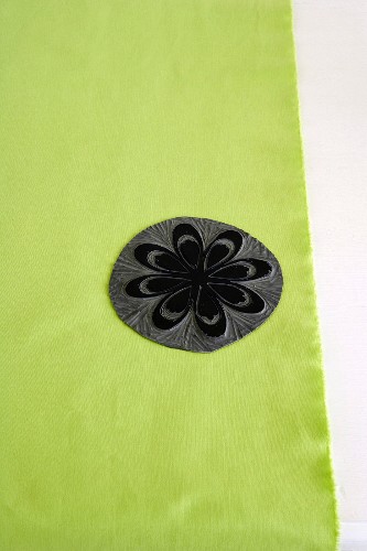 Schwarzer Linolschnitt mit Blumenmotiv auf grünem Stoff