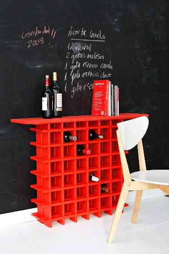 Rotes Weinregal vor einer Wand mit Tafelfarbe mit notiertem Rezept