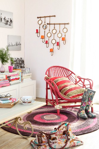 Old rattan armchair painted deep pink on round rug