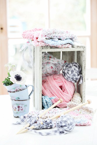 Knitting and ball of rag yarn in wooden crate