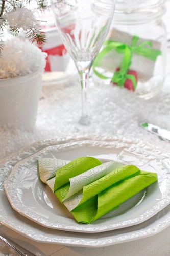 Weihnachtliche Serviettendekoration mit Baummotiv auf weißem Teller
