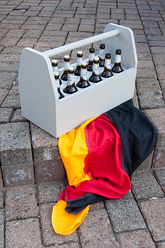 Grauer Flaschenträger für Bier auf einer Deutschland-Flagge