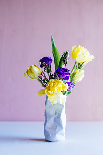 Frühlingsblumen in einer Vase in Form einer zerdrückten Dose