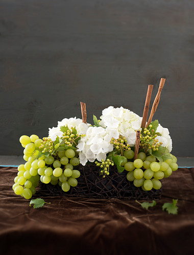 DIY-Gesteck aus weissen Hortensien, Weintrauben und Zimtstangen