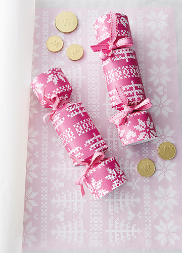 Handmade crackers made from pink paper with cross-stitch pattern