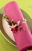 Napkin ring made of silver wire & flowers around purple napkin