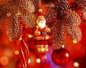 Kleiner Weihnachtsmann als Baumschmuck in rotem Licht