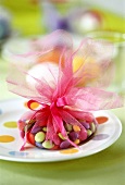 Coloured chocolate beans packed in tulle as Easter gift
