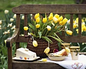Piece of cake, butter dish &  yellow tulips on garden seat