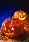 Two pumpkin lanterns for Halloween on straw