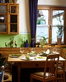 Festlich gedeckter Holztisch mit Stoffservietten und Kerzen in rustikaler Landhausküche