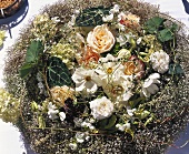 Rosen und weiße Cosmea in einem Nest aus Schleierkraut