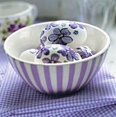 Easter eggs with painted flowers in a bowl