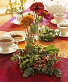 Zinnias & dill in glasses, wreath of hops & Guelder rose berries