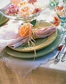 Festliches Gedeck mit grünen Tellern, Serviette & Rose