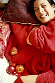 Junge Frau im roten Bademantel mit frischen Äpfeln