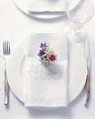 Rustic place-setting with embroidered napkin and flowers