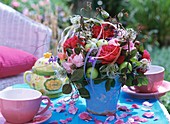 Arrangement of roses, ornamental apples & clematis on tea table
