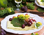 Grapes and vine leaf as place card on napkin