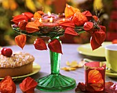 Glass stand with autumn decorations and tea lights