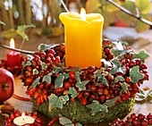 Autumn wreath of rose hips and ivy with candle