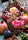 Festive table decoration: roses & rose hips, pomegranate, fig 