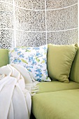 Pale green sofa with cushions and throw