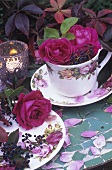 Tisch und Geschirr mit Rosen dekoriert