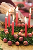 Lighting candles on Christmas wreath