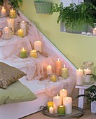 Treppe mit weissen und grünen Kerzen, Tuch und Kissen