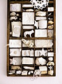 Type case filled with assorted white trinkets