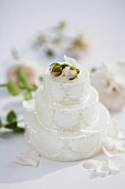 White candle in shape of cake, rose buds