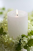 Candle in wreath of hydrangea flowers and mint